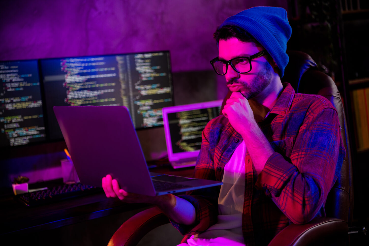 Photo of thoughtful minded programmer wear spectacles thinking reading modern device indoors workplace workshop home.